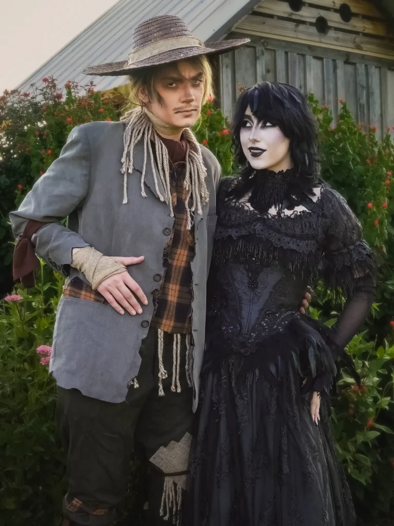 Spooky couple Halloween costumes with a rustic scarecrow in a grey blazer and a gothic woman in a long black lace dress.