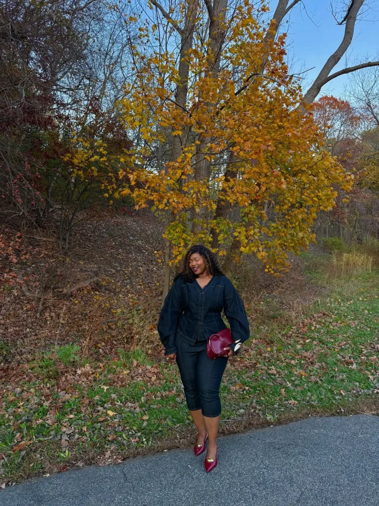 Plus size Black woman wearing a dark indigo denim top with matching cropped jeans, burgundy pointed heels, and a small wine-red handbag for a cute denim fall outfit.