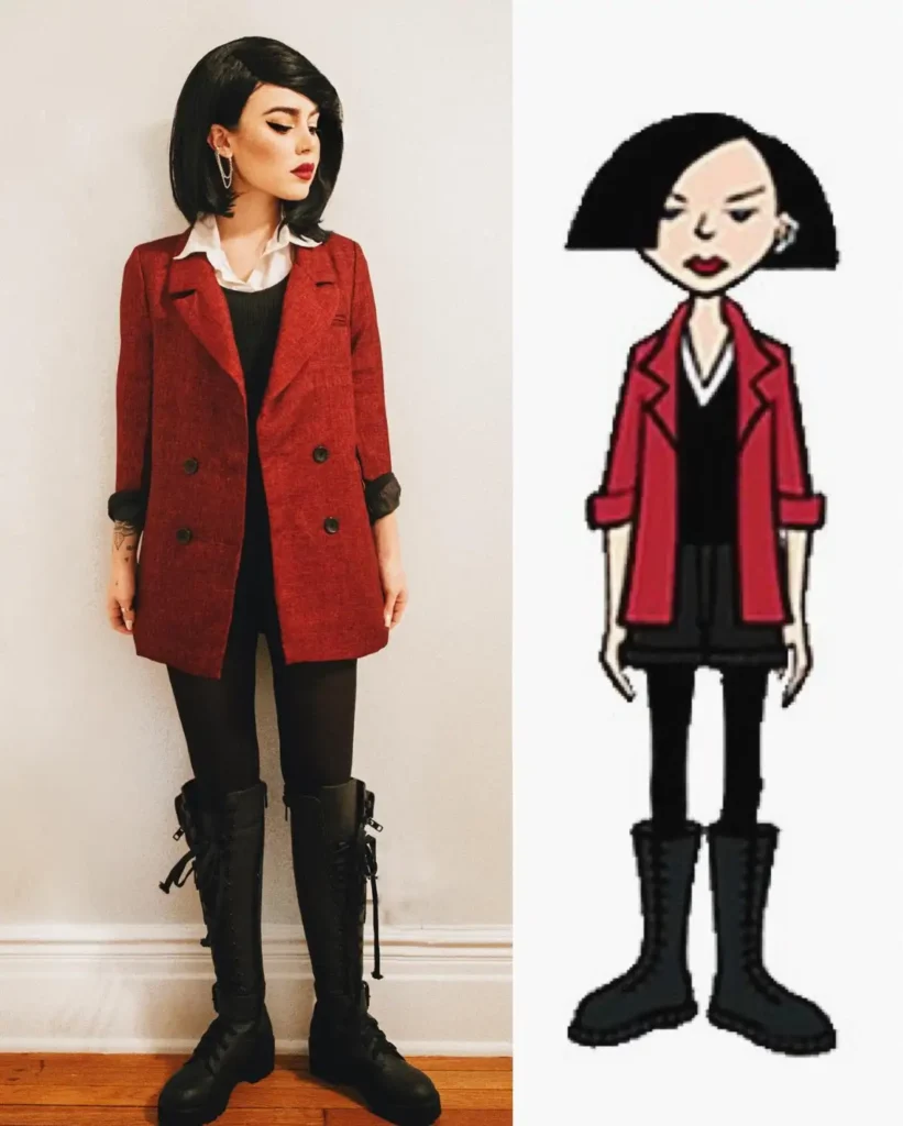 Woman wearing a red double-breasted blazer over black and white layers with black trousers, combat boots, short dark hair, and red lipstick.