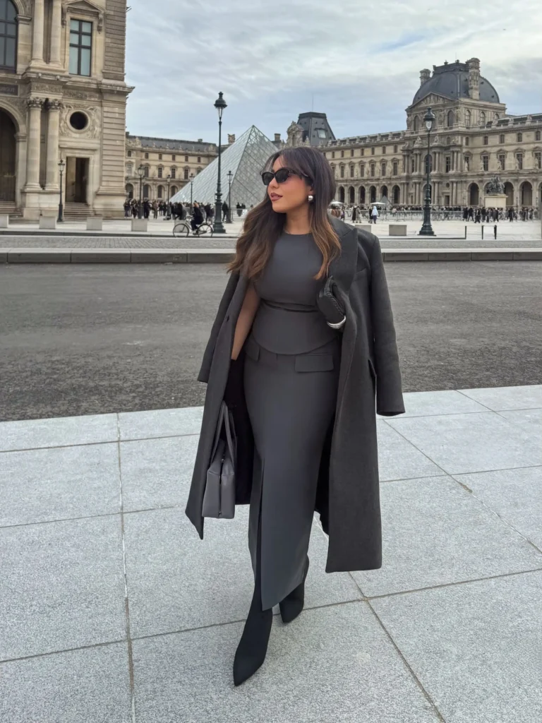 Charcoal fitted top and long skirt styled with an oversized dark gray coat, pointed boots, sunglasses, and a structured bag for elegant autumn fashion.