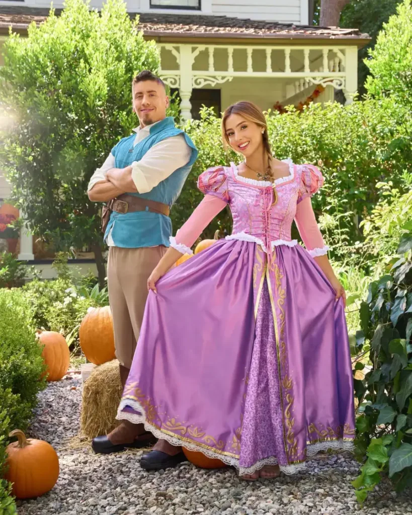 Couple wearing Rapunzel and Flynn Rider costumes with a purple princess dress and blue vest.