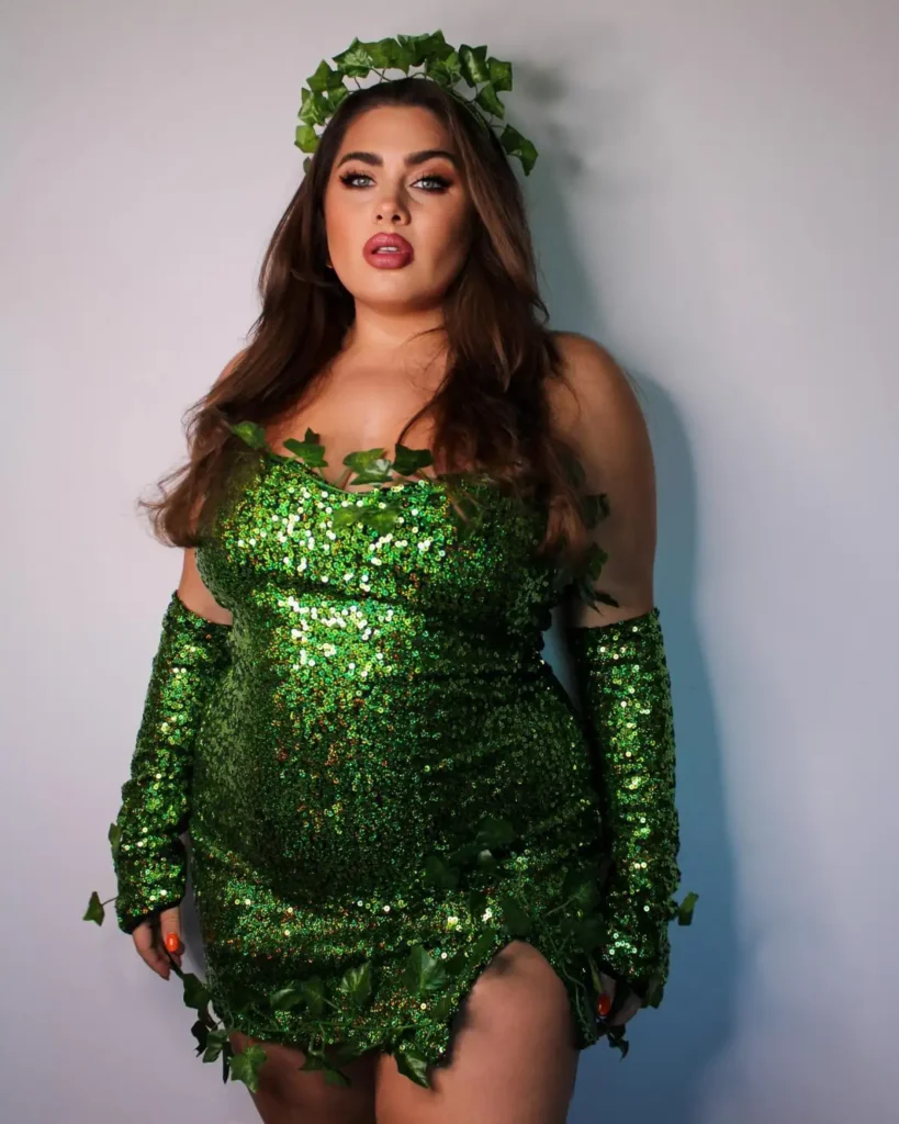 Plus size woman wearing a sparkling green ivy queen Halloween costume with sequins, gloves, and leafy details.