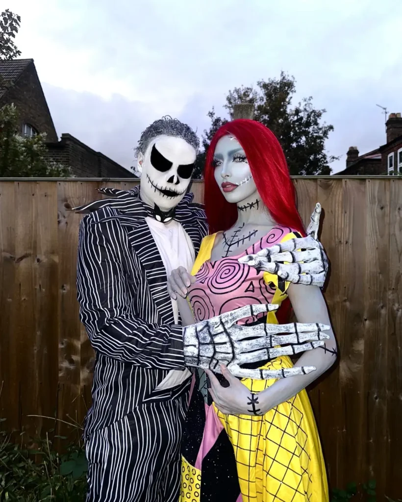 Spooky couple Halloween costumes with a striped skeleton-inspired suit and colorful patchwork doll outfit with red hair.