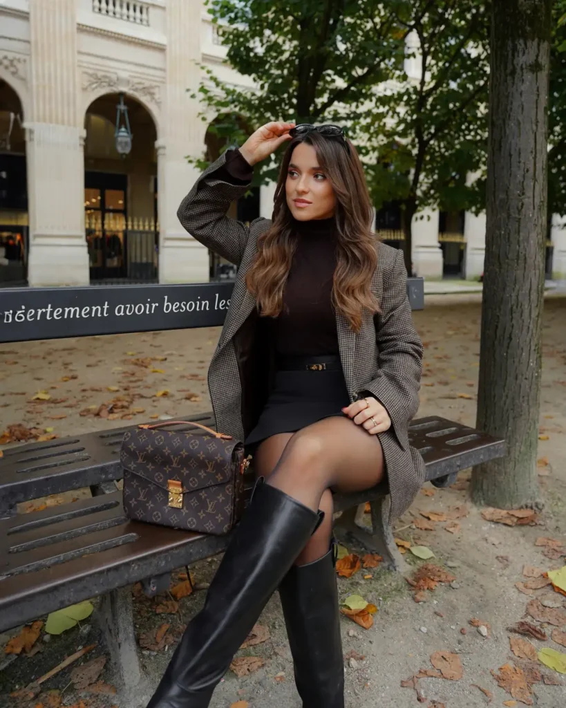 Checked blazer styled with a black turtleneck, mini skirt, sheer tights, and knee-high boots for a polished autumn outfit idea.