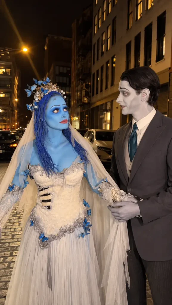 Spooky couple Halloween costumes featuring a blue ghost bride in a white wedding dress beside a pale groom in a grey suit.