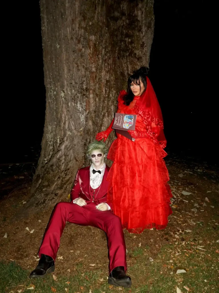 Beetlejuice couple Halloween costume with matching red outfits, green hair and red bridal veil
