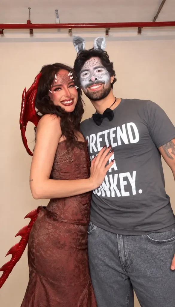 Spooky couple Halloween costumes with a red demon-inspired dress and wings paired with a casual grey bunny costume.