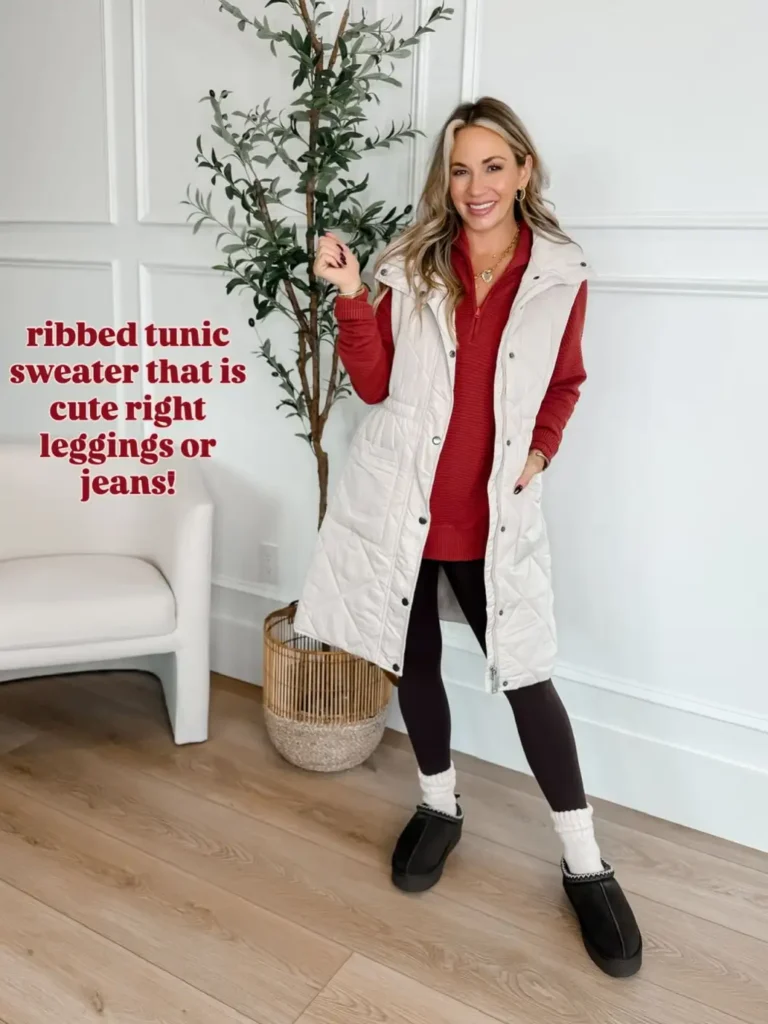 Woman wearing a long cream quilted vest over a red ribbed quarter-zip sweater, black leggings, white socks, and black slip-on shoes for a comfortable cold-weather outfit.