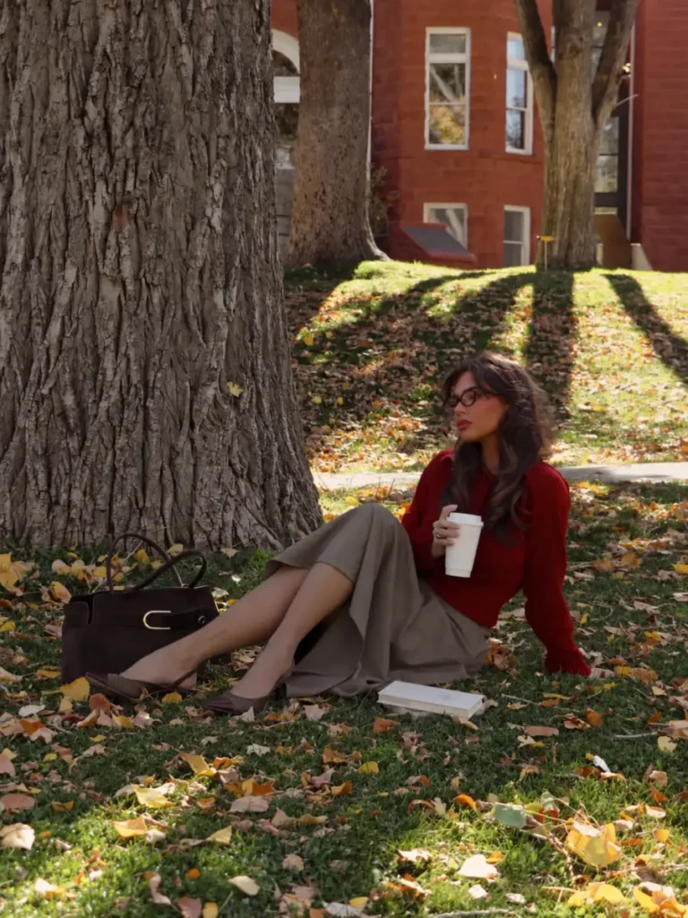 Deep red sweater paired with a taupe midi skirt, brown slingback heels, and a structured brown handbag for fall.